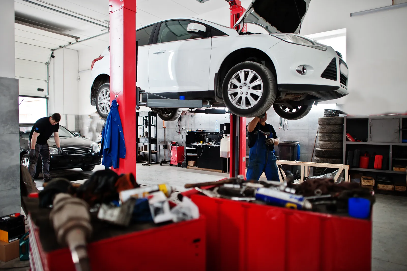 L’atelier du Garage Zanis : véhicules sur pont et mécanicien au travail